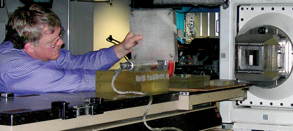 Dr. Richard Wilkins, Director of the NASA Center for Radiation Engineering and Science for Space Exploration (CRESSE), positions a regolith brick between the Loma Linda high energy proton beam path and a tissue equivalent proportional counter to test the material's shielding properties.